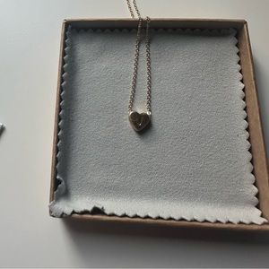 gold necklace with a J initial on a heart